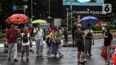 Warga dengan menggunakan payung beraktivitas di tengah rintik hujan pada Car Free Day atau hari bebas kendaraan di kawasan Bundaran Hotel Indonesia (HI), Jakarta, Minggu (12/2/2023). Hujan yang mengguyur Ibu Kota sejak malam sampai pagi ini tak menyurutkan semangat warga untuk tetap berolahraga di area CFD. (Liputan6.com/Johan Tallo)
