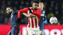 Pemain Atletico Madrid, Juanfran, berupaya menahan laju pemain PSV Eindhoven, Jurgen Locadia pada laga leg pertama babak 16 besar Liga Champions di Stadion PSV, Kamis (25/2/2016). Kedua tim bermain imbang 0-0. (Reuters/Michael Kooren)