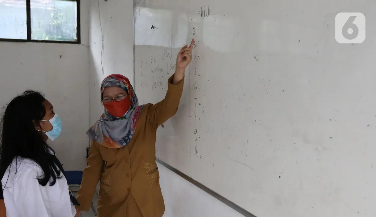 Siswi mengikuti Pembelajaran Tatap Muka Terbatas (PTMT) di SMPN 1 Depok, Depok, Jawa Barat, Senin (4/10/2021). PTMT diberlakukan dengan protokol kesehatan dan pembelajaran hanya dilakukan seminggu dua kali selama dua jam. (Liputan6.com/Herman Zakharia)