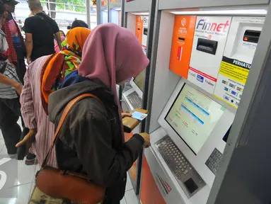Calon penumpang membeli tiket di mesin penjual tiket kereta api otomatis di Stasiun Senen, Jakarta, Selasa (20/12). Jelang libur Natal dan tahun baru tiket Kereta Api sudah habis untuk keberangkatan Jateng dan Jatim. (Liputan6.com/Angga Yuniar)