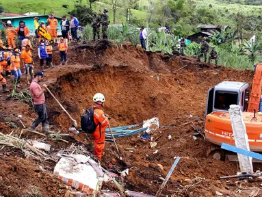 Petugas darurat mencari korban selamat setelah tanah longsor mengubur dua rumah di Mallama, Provinsi Narino, Kolombia, 2 November 2021. Sebanyak empat orang tewas dan beberapa dikhawatirkan terjebak menyusul longsor akibat hujan deras di daerah tersebut. (LEONARDO CASTRO/AFP)