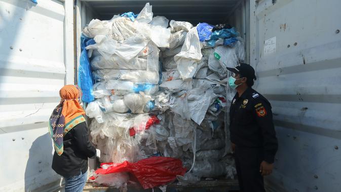 Petugas mengecek peti kemas berisi sampah plastik yang mengandung limbah berbahaya dan beracun (B3) untuk di re-ekspor di Batam, Senin (29/7/2019). Indonesia mengirim kembali (re-ekspor) tujuh peti kemas berisi limbah plastik impor ke negara asalnya, Prancis dan Hongkong. (SEI RATIFA/AFP)