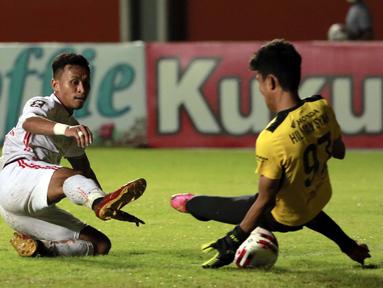 Kiper PSM Makassar, Hilman Syah (kanan) berhasil menghadang tendangan gelandang Persija Jakarta, Osvaldo Haay dalam laga leg pertama semifinal Piala Menpora 2021 di Stadion Maguwoharjo, Sleman, Kamis (15/4/2021). (Bola.com/Ikhwan Yanuar)