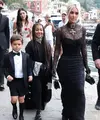 Kim Kardashian tampil nyentrik di hari pernikahan kakaknya itu. Perempuan 41 tahun itu tampil bergaya gothic mengenakan lace dress warna hitam. Gayanya disempurnakan dengan bros dan kalung choker, serta tata rambut high bun. (Instagram/enews).