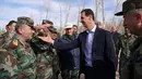 Gambar yang dirilis pada Minggu (18/3), menunjukkan Presiden Suriah Bashar al-Assad mengunjungi pasukan pemerintah di garis depan wilayah Ghouta Timur. Kunjungan dilakukan saat perang di Suriah memasuki tahun ke-8. (HO/SYRIAN PRESIDENCY FACEBOOK PAGE/AFP)