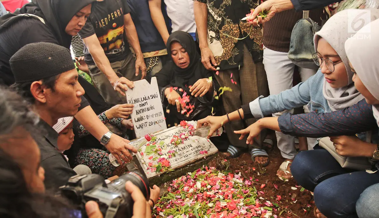 Kerabat dan keluarga menaburkan bunga di pemakaman Laila Sari  Tempat Pemakaman Umum (TPU) Karet Bivak, Jakarta, Selasa (21/11). Laila Sari meninggal dunia saat pulang syuting, di usai 82 tahun. (Liputan6.com/Herman Zakharia)