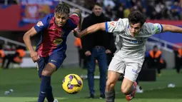 Pemain Barcelona, Lamine Yamal (kiri) berebut bola dengan pemain Deportivo Alaves, Manuel Sanchez dalam laga lanjutan Liga Spanyol 2024/2025 di Estadi Olimpic Lluis Companys, Barcelona, Spanyol, Minggu (02/02/2025) waktu setempat. (AFP/Josep Lago)