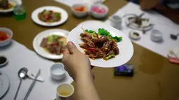 Pramusaji menyajikan hidang dari daging anjing di restoran khusus anjing, Pyongyang House of Sweet Meat, di Korea Utara, Rabu (25/7). Dikenal dengan nama dangogi, daging anjing banyak dikonsumsi oleh masyarakat Korea saat cuaca panas. (AP/Dita Alangkara)