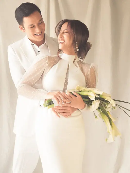 Dengan nuansa yang lebih romantis, pasangan ini kompak dengan busana putih. Janisaa tampil anggun dengan halter neck dress yang dipadukan dengan tulle di bagian lengan. Sedangkan Mike Lewis mengenakan setelan jas putih yang santai (instagram/janisaas)