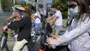 Para komuter yang mengenakan masker menunggu di persimpangan kawasan pusat bisnis di Beijing, China, Selasa (31/5/2022). Penguncian COVID-19 di Shanghai telah mencekik ekonomi nasional dan sebagian besar mengurung jutaan orang di rumah mereka. (AP Photo/Mark Schiefelbein)