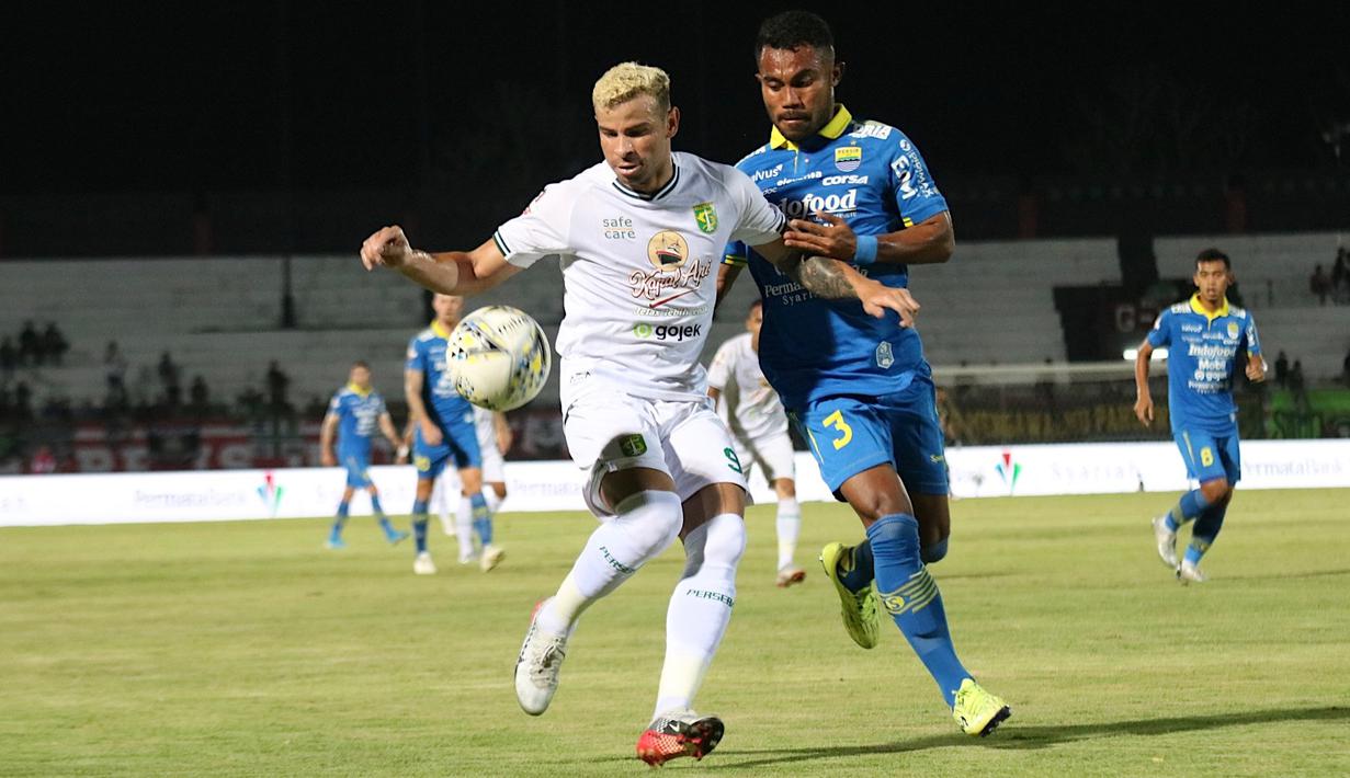Gelandang Persebaya Surabaya, Diogo Campos, berebut bola dengan bek Persib Bandung, Ardi Idrus, pada laga Liga 1 Indonesia di Stadion I Wayan Dipta, Bali, Jumat (18/10). Persib menang 4-1 atas Persebaya. (Bola.com/Aditya Wany)