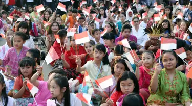 Ratusan anak-anak mengibarkan bendera Merah Putih saat gelaran Harmoni Indonesia 2018 di Kompleks Gelora Bung Karno, Jakarta, Minggu (5/8). Presiden RI, Joko Widodo hadir dalam acara tersebut. (Liputan6.com/Helmi Fithriansyah)