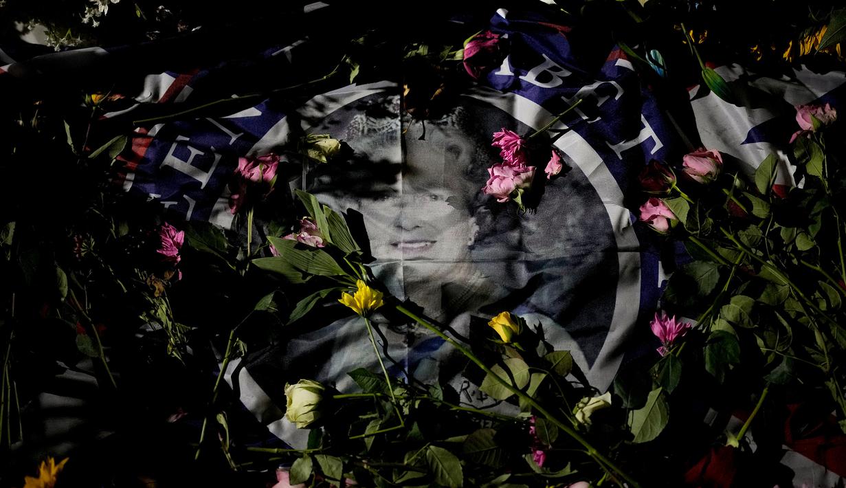 Potret Ratu Elizabeth II ditutupi oleh bunga penghormatan di Green Park London, Senin (12/9/2022). Ratu Elizabeth II merupakan raja Inggris yang paling lama memerintah dan membantu stabilitas di sebagian kawasan yang bergejolak, meninggal pada hari Kamis 8 September 2022, setelah 70 tahun berkuasa, pada usia 96 tahun. (AP Photo/Andreea Alexandru)