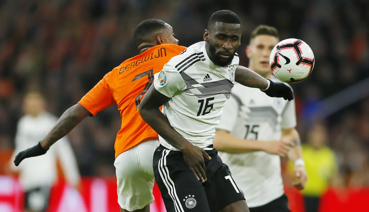Pemain Belanda, Steven Bergwijn, duel udara dengan bek Jerman, Antonio Rudiger, pada laga kualifikasi Piala Eropa di Stadion Johan Cruyff, Minggu (24/3). Belanda takluk 2-3 dari Jerman. (AP/Peter Dejong)