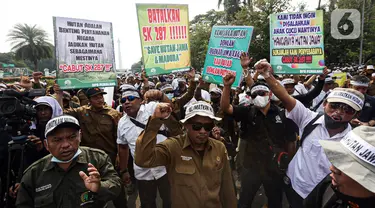 Sejumlah orang yang tergabung dalam karyawan Perhutani menggelar aksi damai di kawasan Patung Kuda, Jakarta, Rabu (20/7/2022). Massa menyampaikan kepada masyarakat Indonesia dan pemerintah peran strategis Hutan Jawa dalam mendukung kehidupan baik dari aspek ekologis, tata air, mitigasi bencana, perlindungan keanekaragaman hayati, perekonomian, sosial dan budaya mengingat peran strategis tersebut. (Liputan6.com/Faizal Fanani)