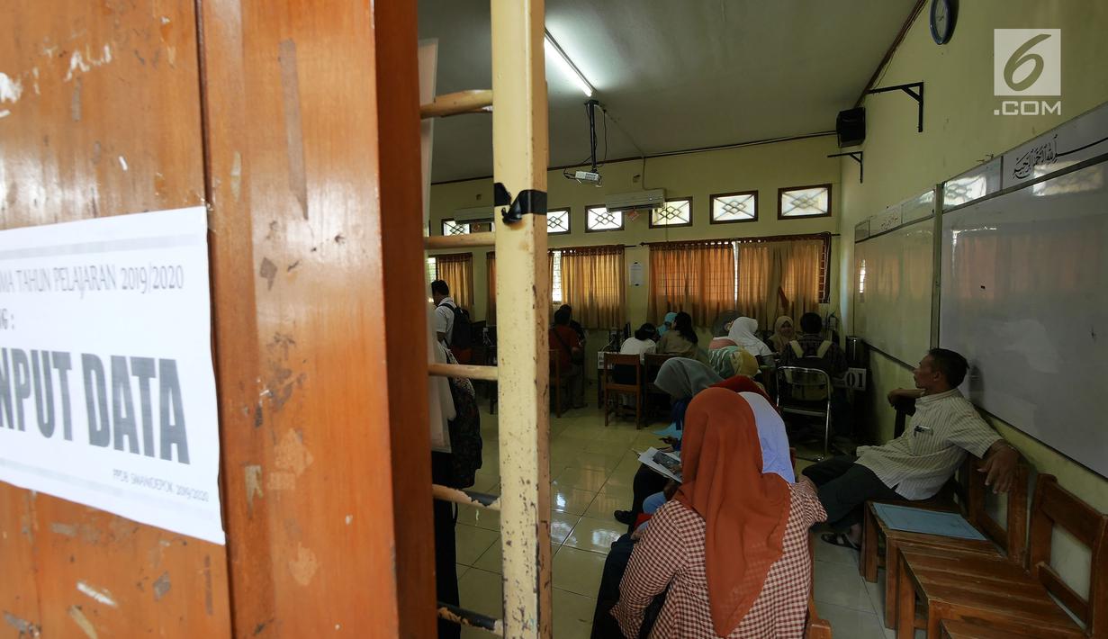 Siswa dan orangtua murid melakukan input data saat mengikuti seleksi Penerimaan Peserta Didik Baru (PPDB) di SMAN 1 Depok, Kota Depok, Jawa Barat, Selasa (18/6/2019). PPDB SMA dibagi menjadi tiga jalur yakni zonasi, prestasi, dan pemindahan orangtua. (Liputan6.com/Herman Zakharia)