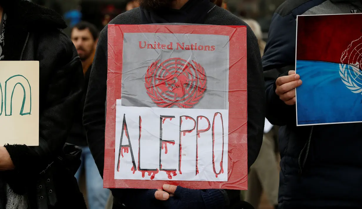 Pengunjuk rasa Israel membawa tulisan Aleppo yang terlihat berdarah, Jumat (16/12). Mereka mengaku prihatin dengan warga Aleppo di Suriah. (REUTERS / Baz Ratner)