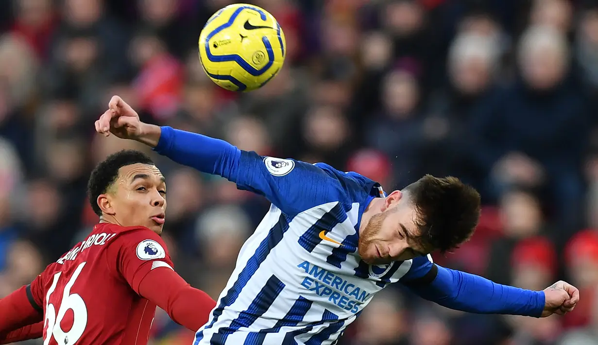 Bek Liverpool, Trent Alexander-Arnold, duel udara dengan striker Brighton, Aaron Connolly, pada laga Premier League di Stadion Anfield, Liverpool, Sabtu (1/12). Liverpool menang 2-1 atas Brighton. (AFP/Paul Ellis)