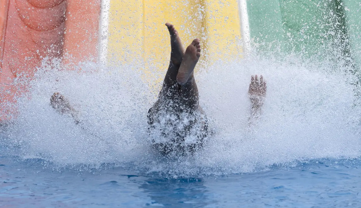 Pengunjung berseluncur saat berenang di Siam Amazing Park, Bangkok, Thailand, Rabu (17/6/2020). Keseharian warga Bangkok berangsur normal setelah pemerintah terus melonggarkan pembatasan terkait pandemi virus corona COVID-19. (AP Photo/Sakchai Lalit)
