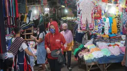 Pedagang dan pembeli mengenakan masker saat beraktivitas di Pasar Minggu yang kembali buka setelah penutupan selama tiga hari, Jakarta, Selasa (23/6/2020). Sebelumnya, Pasar Minggu ditutup sementara setelah tiga pedagang dinyatakan positif COVID-19. (Liputan6.com/Immanuel Antonius)