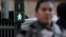Seorang wanita berjalan melewati lampu lalu lintas untuk penyeberang jalan dengan gambar sosok perempuan terlihat saat Peringatan Hari Perempuan Internasional di Valencia, Spanyol, Selasa (8/3/2016). (REUTERS/Heino Kalis)