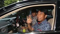 Haji Lulung memperlihatkan salam tiga jari usai diperiksa Bareskrim di Ombudsman, Jakarta, Rabu (12/4). Lulung mengaku tidak terlibat pembahasan proyek pengerjaan revitalisasi gedung Teater Kesenian Jakarta. (Liputan6.com/Helmi Afandi) 