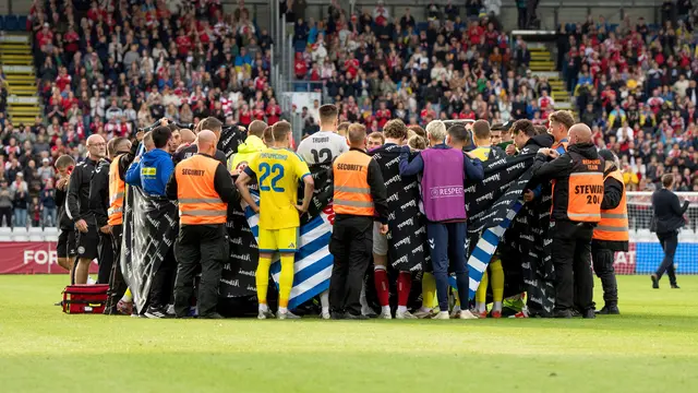 Pemain Timnas Denmark dan Timnas Ukraina membentuk lingkaran di sekitar Christian Eriksen yang jatuh pingsan di tengah pertandingan di Odensen, Denmark, Minggu (07/06/2026) malam WIB.