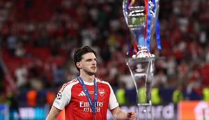 Gelandang Inggris, Declan Rice, berjalan melewati trofi setelah Arsenal kalah dari Paris Saint-Germain pada final Liga Champions, di Puskas Arena, Minggu (31/5/2026) dini hari WIB. (Franck Fife/AFP)
