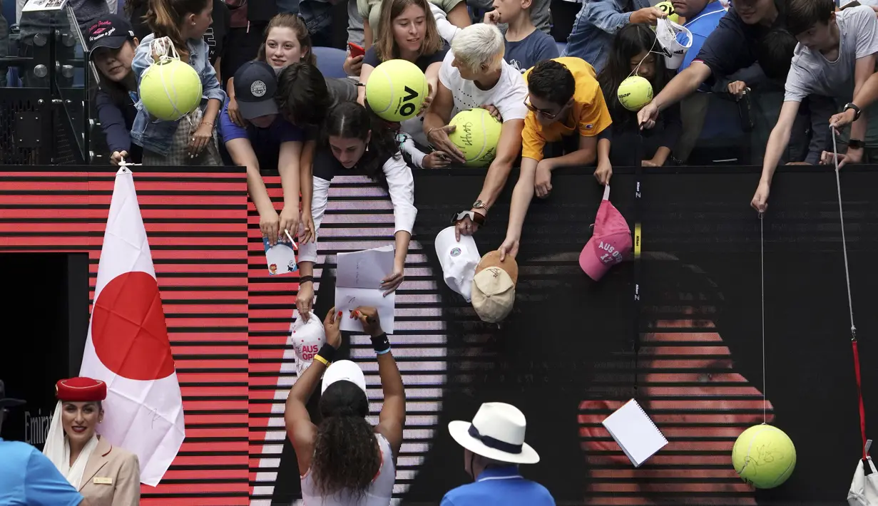 Petenis Naomi Osaka memberikan tandatangan ke fans usai bertanding melawan Marie Bouzkova pada pertandingan putaran pertama tenis Australia Terbuka di Rod Laver Arena, Melbourne, Australia, Senin (20/1/2020). Osaka akan bertemu Zheng Saisai dari China pada putaran kedua. (AP Photo/Lee Jin-man)