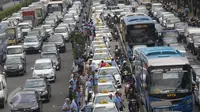 Deretan taksi terlihat diparkir di jalur Transjakarta di Jalan Gatot Subroto, Jakarta, Selasa (22/3). Ribuan sopir taksi memblokir jalan protokol tersebut hingga menyebabkan kemacetan total di kawasan itu. (Liputan6.com/Immanuel Antonius)