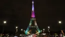 Pengunjung berjalan di sekitar Menara Eiffel yang diterangi dengan huruf bertuliskan '300 juta terima kasih' di Paris, Kamis (28/9). Menara Eiffel pada Kamis waktu setempat merayakan pengunjung ke-300 jutanya sejak dibuka pada 1889. (LUDOVIC MARIN/AFP)