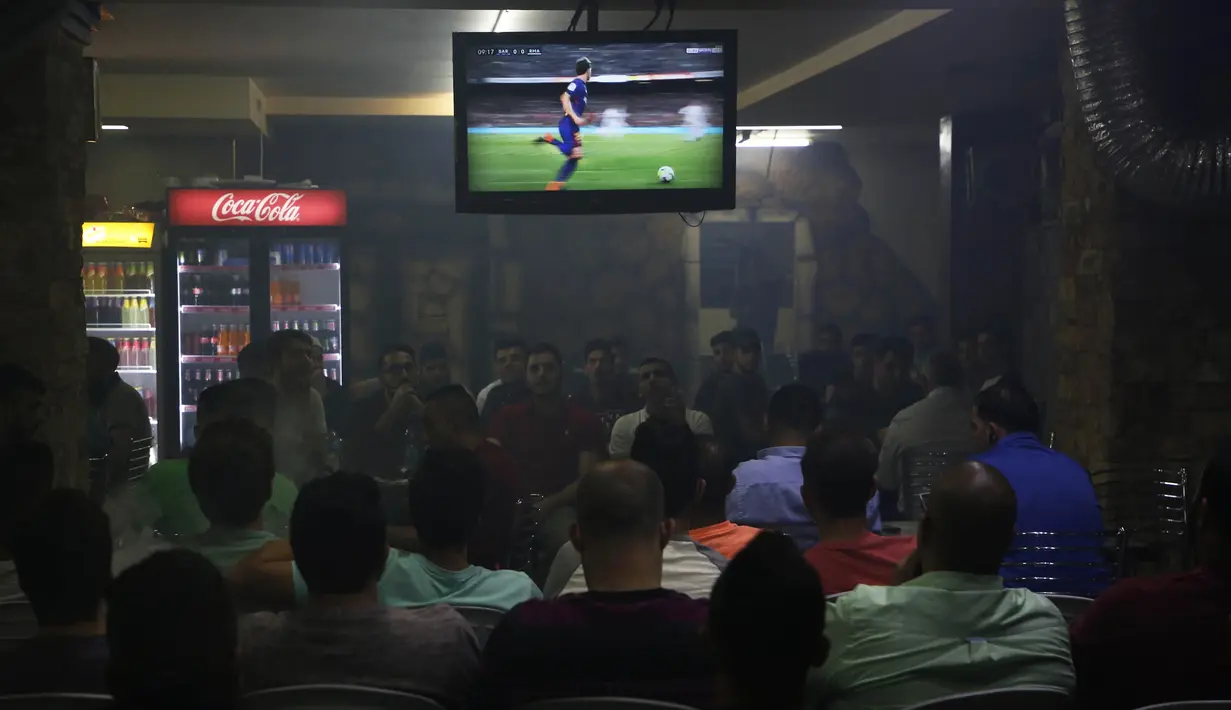 Warga Palestina menonton laga El Clasico antara Barcelona melawan Real Madrid di West Bank City, Ramallah, Minggu (6/5/2018). Konflik perang tak menyurutkan fenomena El Clasico. (AFP/Abbas Momani)