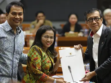 Menkumham Yasonna Laoly (kanan) menunjukkan dokumen saat rapat pleno terkait amnesti untuk Baiq Nuril dengan Komisi III DPR di Gedung Nusantara II, Jakarta, (24/7/2019). DPR setuju Presiden Joko Widodo atau Jokowi memberikan amnesti kepada Baiq Nuril. (Liputan6.com/JohanTallo)