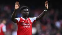 Gelandang Arsenal, Bukayo Saka memberi penghormatan kepada fans usai berakhirnya laga menghadapi Crystal Palace pada laga Liga Inggris 2022/2023 di Emirates Stadium, London (19/3/2023). Serupa dengan Gabriel Martinelli, Bukayo Saka juga tak pernah absen membela Arsenal dalam 33 laga di Liga Inggris musim 2022/2023. Ketajamannya sebagai pencetak gol dan assist sama baiknya, dengan koleksi 13 gol dan 11 assist. (AFP/Justin Tallis)