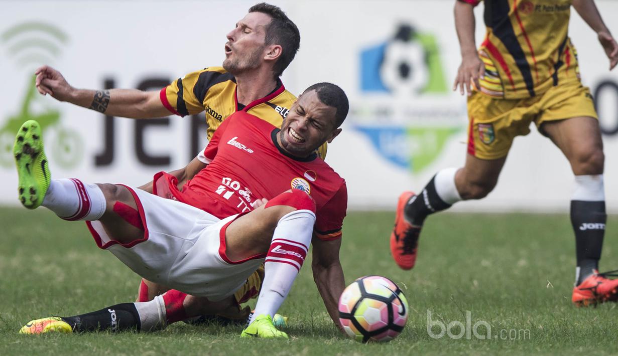 Striker Persija, Luiz Junior, dijatuhkan bek Mitra Kukar, Jorge Gotor, pada laga Liga 1 di Stadion Patriot, Bekasi, Minggu (14/5/2017). Kedua tim bermain imbang 1-1. (Bola.com/Vitalis Yogi Trisna)