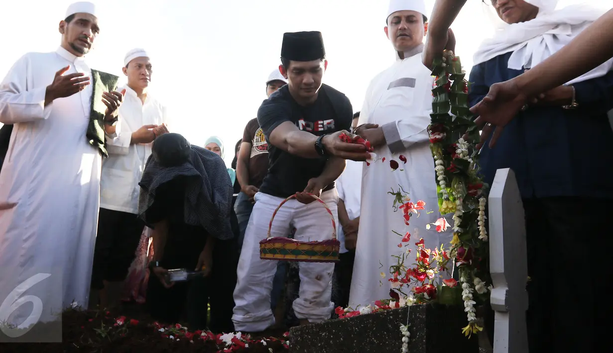  Aktor Iko Uwais menaburkan bunga di pemakaman ayahnya Musthafa Kamaluddin di TPU Prumpung, Jakarta, Rabu (8/3). Ayah Iko Uwais wafat pada  Rabu (8/3/2017) pagi di RSCM. (Liputan6.com/Herman Zakharia)