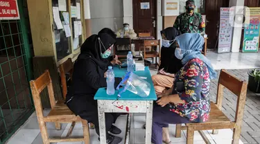 Petugas kesehatan melakukan rapid test massal Covid-19 di SDN Petamburan 01, Petamburan, Jumat (27/11/2020). Kodim 0501 Jakarta Pusat dan Polda Metro Jaya kembali menggelar rapid test massal di kawasan Petamburan setelah sebelumnya menemukan lima orang yang reaktif. (Liputan6.com/Johan Tallo)