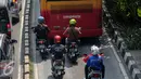 Sejumlah kendaran bermotor berjalan di belakang bus Transjakarta di Jakarta, Rabu (24/6/2015). Pemprov DKI Jakarta berencana meninggikan jalur bus Transjakarta dengan memasang movable concrete barrier (MCB) dan pintu otomatis. (Liputan6.com/Faizal Fanani)
