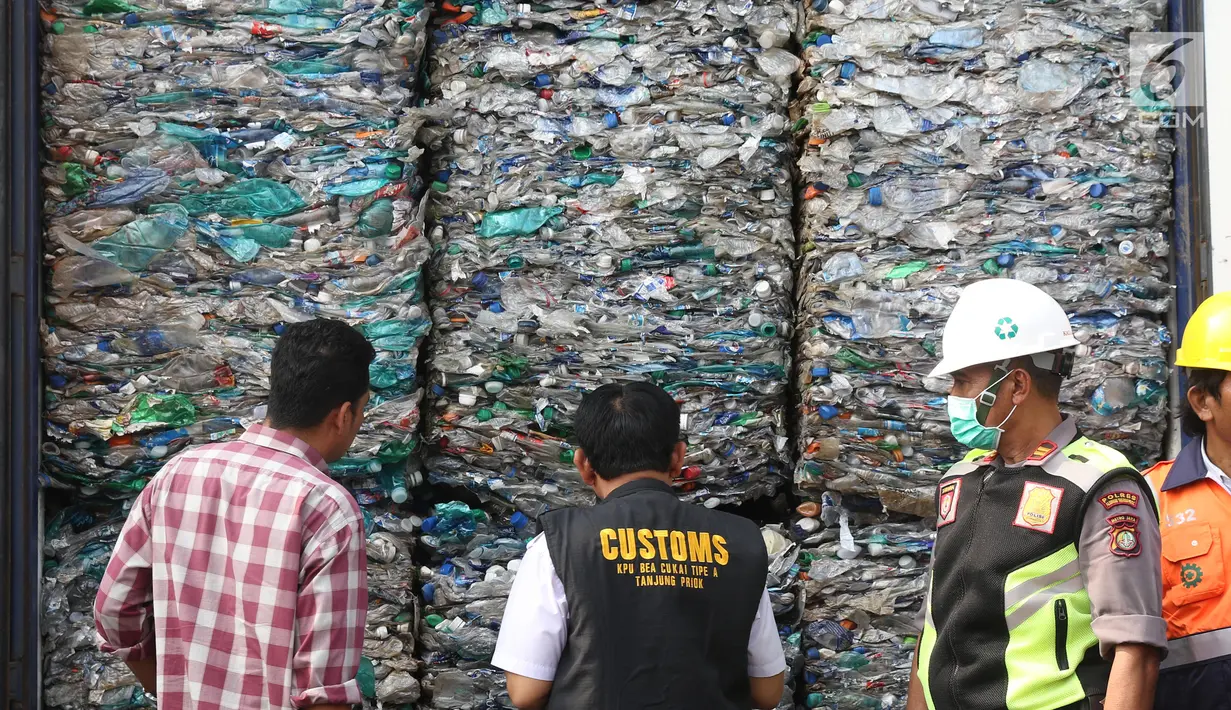 Petugas Bea Cukai serta polisi menunjukkan kontainer berisi sampah plastik di Tanjung Priok, Jakarta, Rabu (18/9/2019). Bea Cukai bekerja sama dengan KLHK dan kepolisian memulangkan sembilan kontainer berisi 135 ton sampah plastik impor bercampur limbah B3 asal Australia. (Liputan6.com/Angga Yuniar)