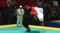 Pesilat Indonesia Pipiet Kamelia berselebrasi membawa bendera Merah Putih usai mengalahkan Thi Cam Nhi Nguyen dari Vietnam pada final nomor 60-65 kg putri pencak silat Asian Games 2018, Jakarta, Rabu (29/8). (Merdeka.com/Imam Buhori)