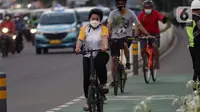 Warga mengenakan masker bersepeda di jalan Jenderal Sudirman, Jakarta, Jumat (25/6/2021). Hari ini Jumat (25/6), Provinsi DKI Jakarta mencatat penambahan kasus konfirmasi positif Covid-19 sebanyak 6.934 orang. (Liputan6.com/Helmi Fithriansyah)