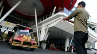 Seorang pria mengambil foto mobil bercorak Ulos Mandailing yang akan digunakan acara ngunduh mantu Kahiyang-Bobby di Medan, Senin (20/11). (Liputan6.com/JohanTallo)