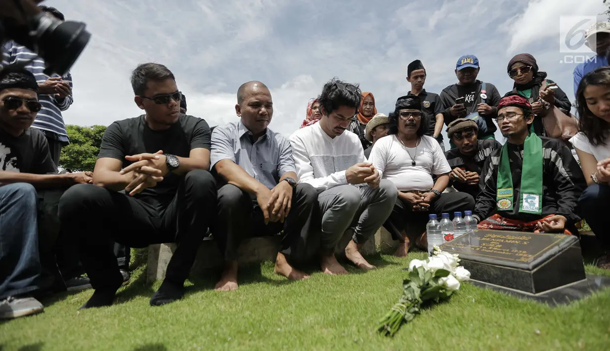 Aktor Reza Rahadian selaku pemeran Benyamin Sueb dalam film Benyamin: Biang Kerok berdoa saat ziarah ke makam Benyamin Sueb di Karet Bivak, Jakarta, Jumat (26/1). (Liputan6.com/Faizal Fanani)