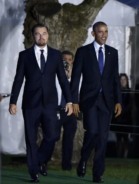 Aktor Leonardo DiCaprio dan Presiden AS Barack Obama berjalan menghadiri diskusi membahas perubahan iklim selama "South by South Lawn" (SXSL) festival di Gedung Putih (3/10). (AFP PHOTO/Mandel NGAN)