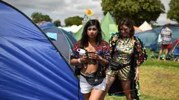 Dua wanita keluar dari tenda selama Festival Glastonbury di Worthy Farm, Somerset, Inggris (30/6/2019). Festival Glastonbury merupakan festival musik paling populer di dunia yang berlangsung lima hari. (AFP Photo/Oli Scarff)