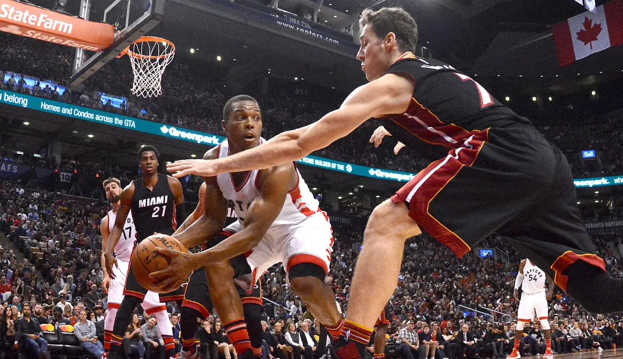 Pemain Toronto Raptors, Kyle Lowry #7 mencoba melewati hadangan pemain Miami Heat, Goran Dragic (kanan) pada laga NBA di Air Canada Centre, (4/11/2016). Raptors menang 96-87. (Reuters/Dan Hamilton-USA TODAY Sports)