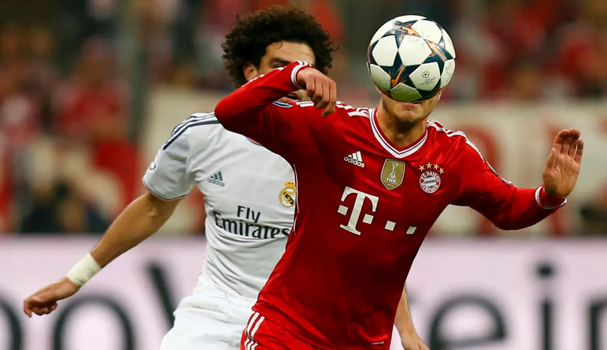 Pepe (Real Madrid-kiri) mencoba merebut penguasaan bola dari Mario Gotze (Bayern Munich) saat laga kedua semifinal Liga Champions yang digelar di Allianz Arena, Munich (30/4/2014). (REUTERS/Ralph Orlowski)