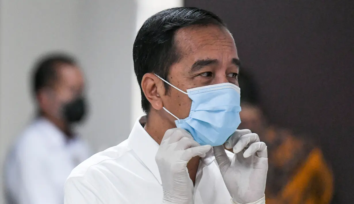 Presiden Joko Widodo merapihkan masker yang digunakannya saat meninjau Rumah Sakit Darurat Penanganan COVID-19 Wisma Atlet Kemayoran, Jakarta, Senin (23/3/2020). Dalam kunjungannya Jokowi memastikan Rumah Sakit Darurat siap digunakan untuk menangani 3.000 pasien. (ANTARA FOTO/Hafidz Mubarak A/Pool)
