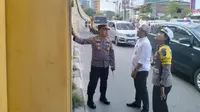 Personel Polresta Pekanbaru dan pejabat dari Pemerintah Provinsi Riau mengecek jembatan retak di Pekanbaru. (Liputan6.com/M Syukur)