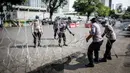 Polisi memasang kawat berduri saat aksi solidaritas untuk rakyat Palestina di Depan Kedutaan Besar Amerika Serikat, Jakarta (18/5/2021). Massa mengutuk dan mengecam keras kekerasan yang dilakukan Israel atas Palestina. (Liputan6.com/Faizal Fanani)